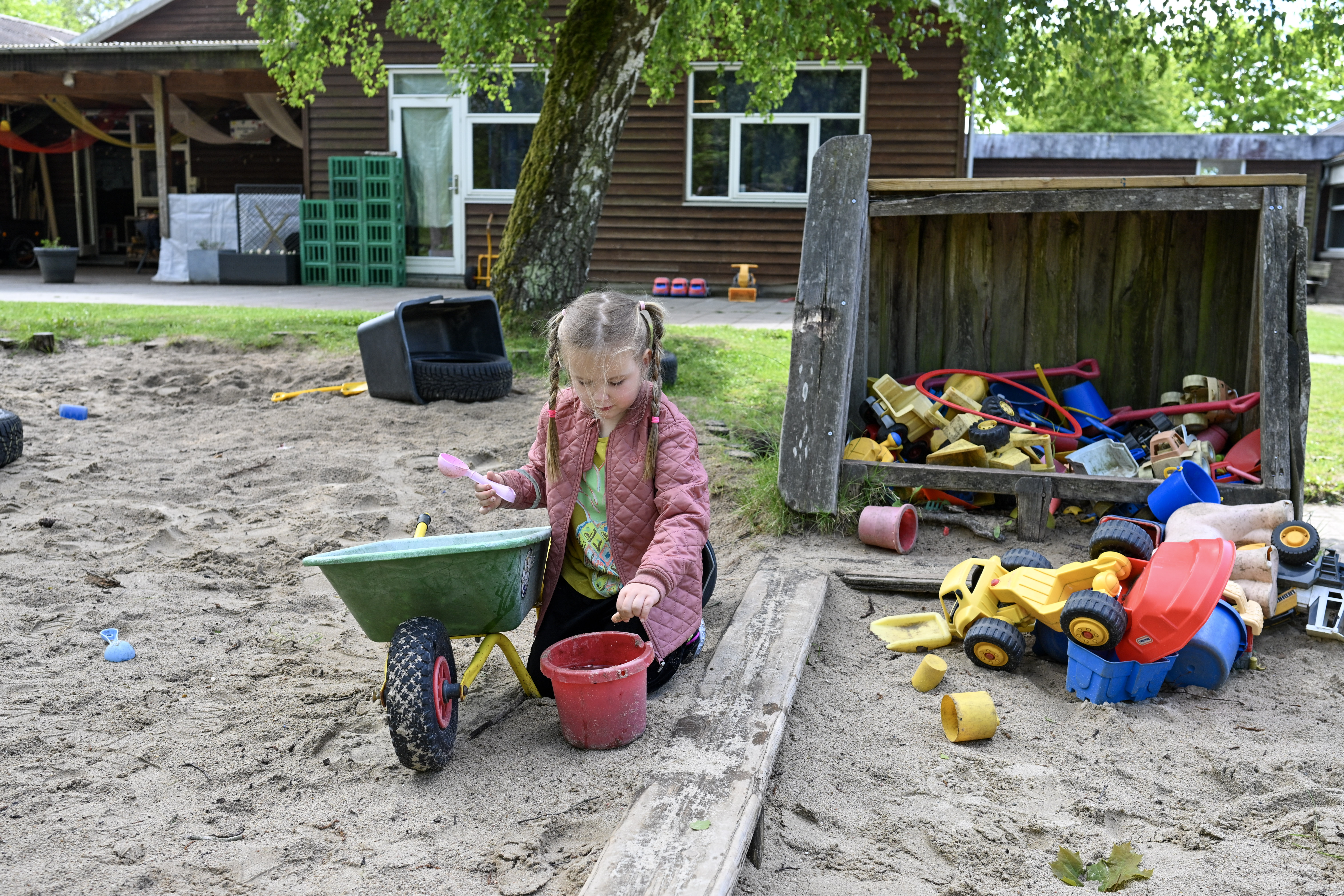 Pige leger i sandkasse