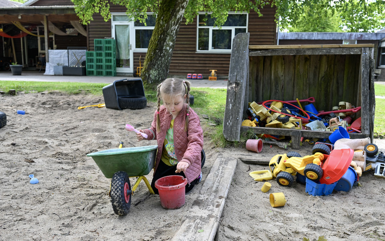 Pige leger i sandkasse