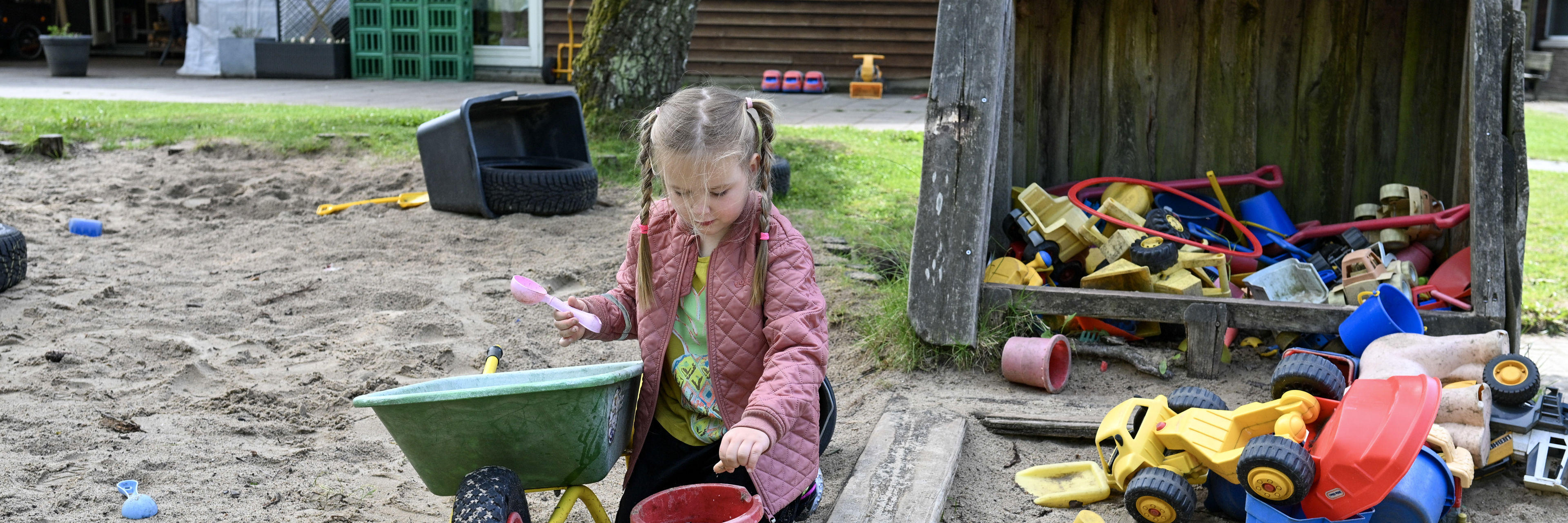 Pige leger i sandkasse