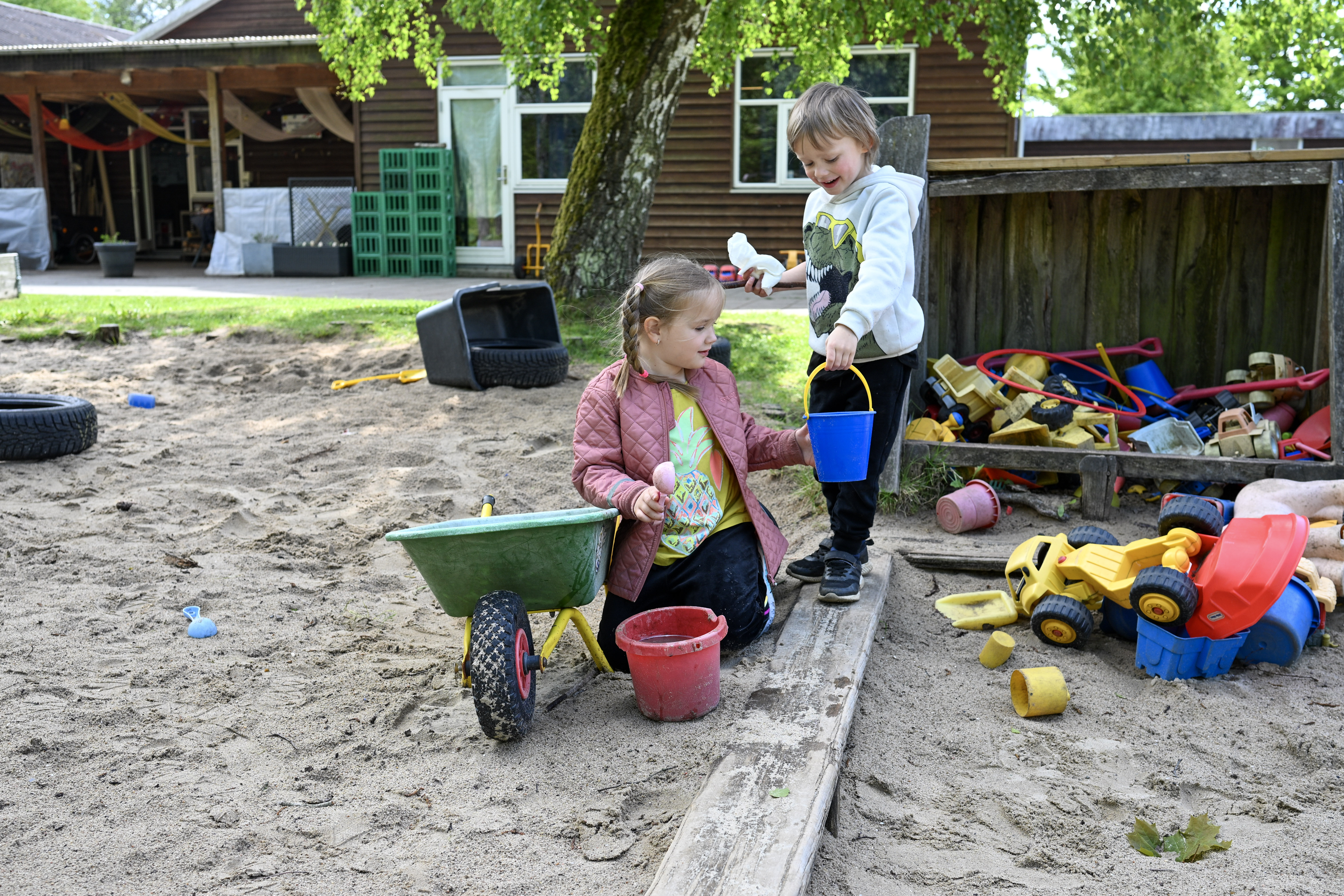 Pige og dreng leger i sandkasse