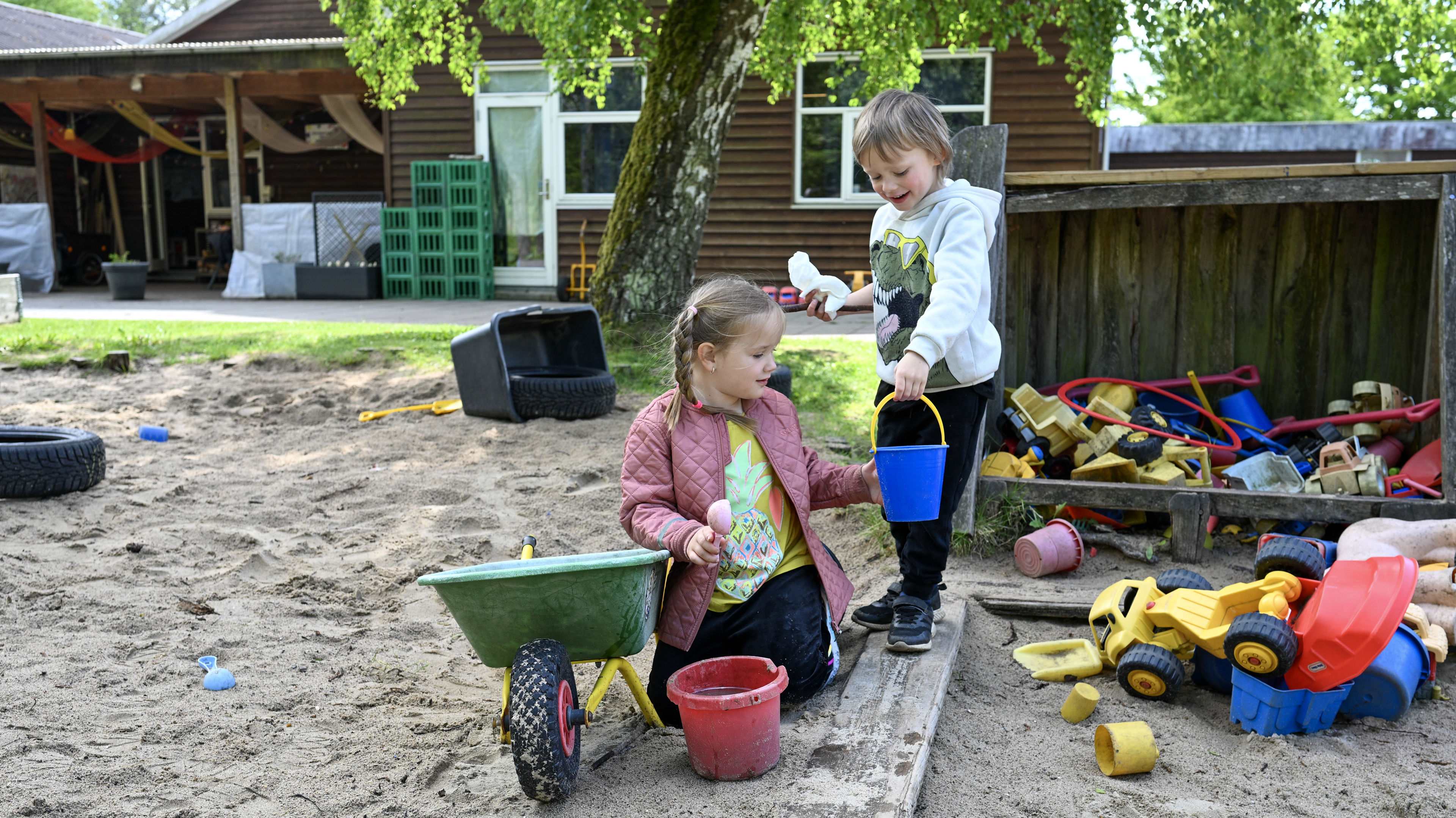 Pige og dreng leger i sandkasse